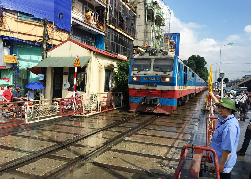 Nhân viên gác chắn đường sắt thực hiện công tác đảm bảo an toàn chạy tàu. (Ảnh: Việt Hùng/Vietnam+)