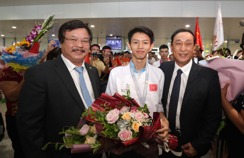 Tổng Cục trưởng Tổng cục Giáo dục nghề nghiệp Nguyễn Hồng Minh tặng hoa cho thí sinh Trương Thế Diệu đạt Huy chương Bạc Kỳ thi tay nghề thế giới lần thứ 45 nghề Phay CNC tại Sân bay quốc tế Nội Bài. (Ảnh: Anh Tuấn/TTXVN)