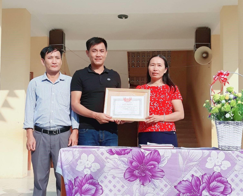 Tặng Giấy khen thầy giáo Đồng Văn Nhân vì hành động dũng cảm cứu người. (Ảnh: Bích Huệ/TTXVN)