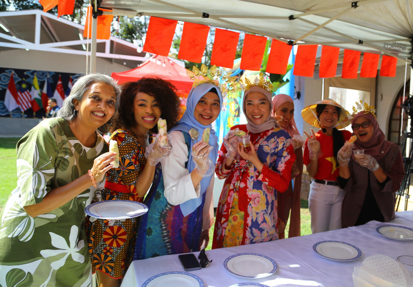 Các khách mời ở Nam Phi hào hứng khoe sản phẩm nem cuốn tự tay làm. (Ảnh: Hồng Minh/ TTXVN)