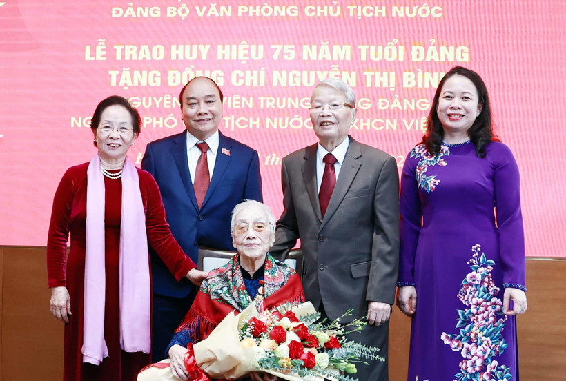 Chủ tịch nước Nguyễn Xuân Phúc và các đại biểu tại Lễ trao tặng huy hiệu 75 năm tuổi Đảng cho bà Nguyễn Thị Bình, nguyên Ủy viên Trung ương Đảng, nguyên Phó Chủ tịch nước CHXHCN Việt Nam. (Ảnh: Thống Nhất/TTXVN)