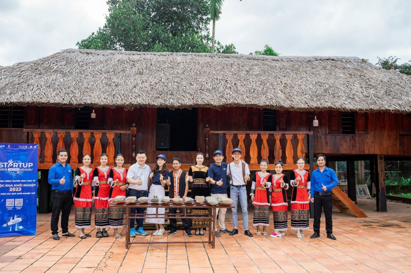 Nhóm các bạn trẻ Khanh Son Eco cùng đoàn khách du lịch chụp ảnh lưu niệm tại nhà dài của người đồng bào dân tộc Raglai, nhằm giới thiệu một sản phẩm văn hóa của huyện Khánh Sơn. (Ảnh: TTXVN phát)