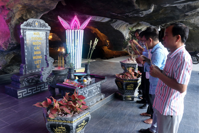 Du khách thắp hương tưởng niệm các Anh hùng liệt sỹ trước cửa hang Quân y núi Mo So, xã Bình An, huyện Kiên Lương. (Ảnh: Lê Huy Hải /TTXVN)