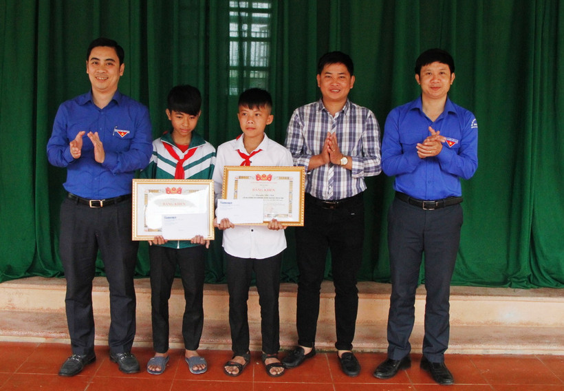 Trao bằng khen của Tỉnh đoàn và tiền thưởng cho hai em học học sinh Nguyễn Văn Chương và học sinh Nguyễn Phi Anh. (Ảnh: Phan Quân/TTXVN) 