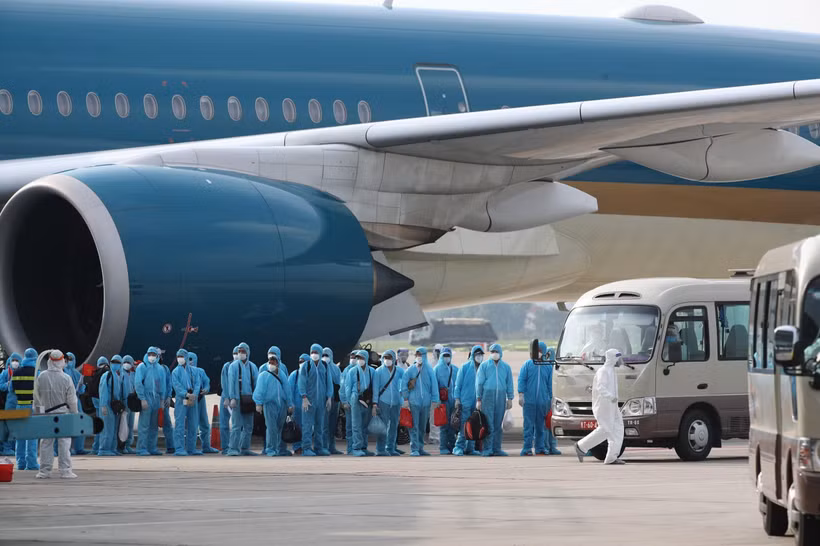 Các công dân xuống máy bay vào xe để về khu cách ly y tế. (Ảnh: Thành Đạt/TTXVN)