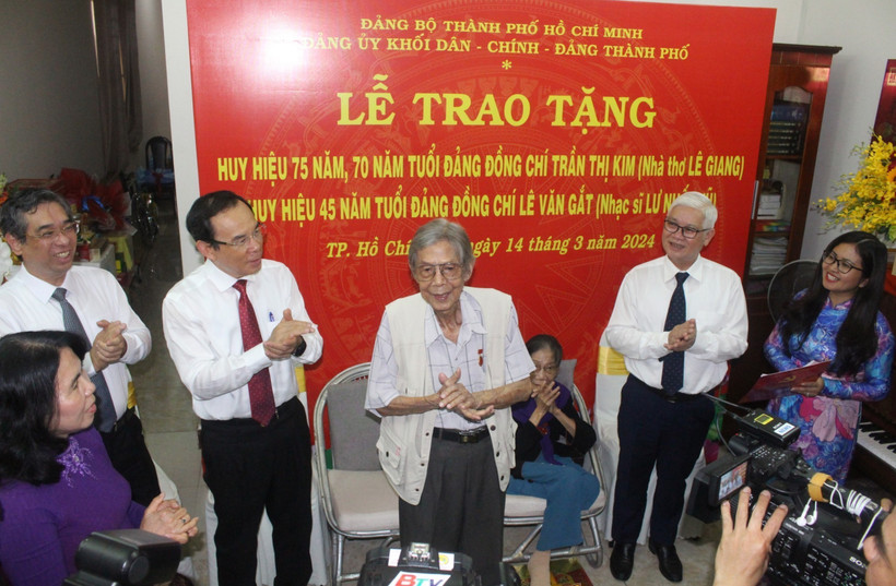 Bí thư Thành ủy Thành phố Hồ Chí Minh Nguyễn Văn Nên trao huy hiệu Đảng cho nhà thơ Lê Giang và nhạc sỹ Lư Nhất Vũ. (Ảnh: Chí Tưởng/TTXVN)