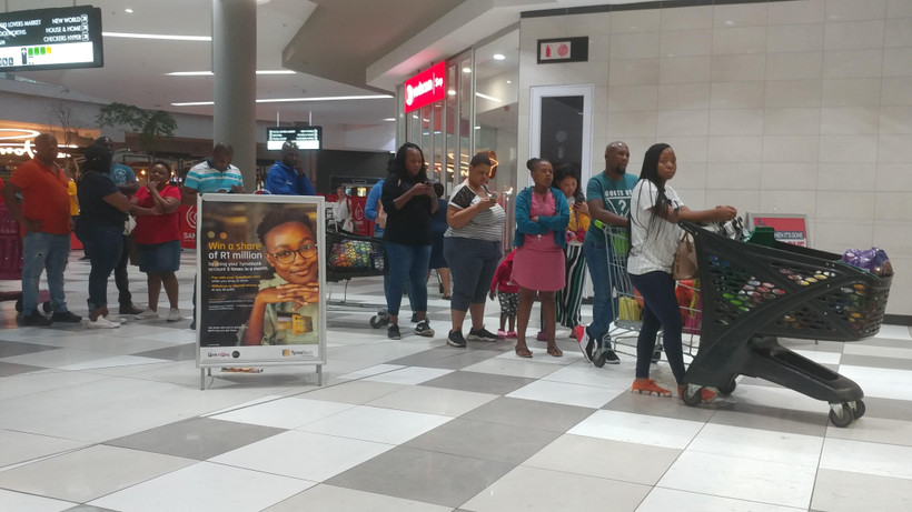 Người dân xếp hàng trong trung tâm thương mại Menlyn tại thủ đô Pretoria tối 26/3 để mua lương thực, thực phẩm tích (Ảnh: Phi Hùng/TTXVN)