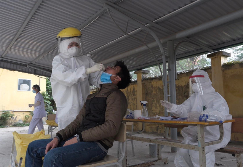 Nhân viên y tế lấy mẫu xét nghiệm COVID-19 với người có tiếp xúc gần với ca F0 tại Hà Nội. (Ảnh: Phạm Hùng - TTXVN phát)