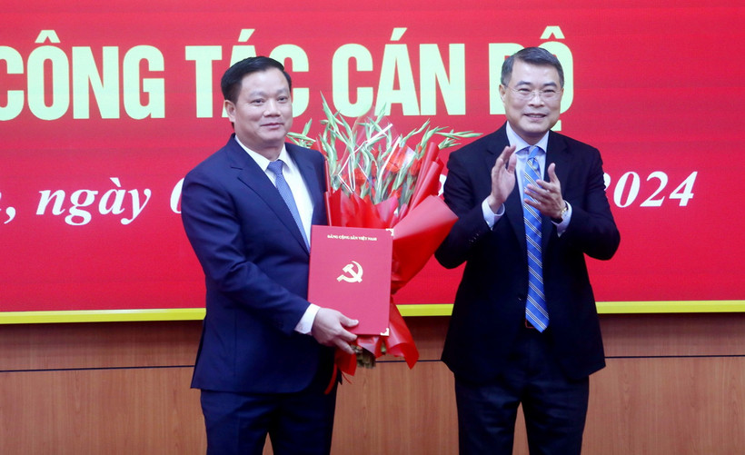 Đồng chí Lê Minh Hưng, Ủy viên Bộ Chính trị, Bí thư Trung ương Đảng, Trưởng Ban Tổ chức Trung ương trao Quyết định, tặng hoa chúc mừng đồng chí Nguyễn Khắc Thận. (Ảnh: Thế Duyệt/TTXVN)