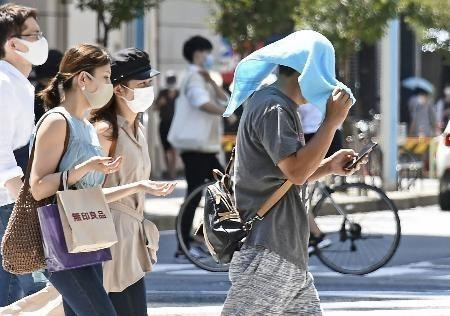 Người dân di chuyển dưới tiết trời nắng nóng kỷ lục tại Nagoya, Nhật Bản ngày 16/8/2020. (Ảnh: Kyodo/TTXVN)