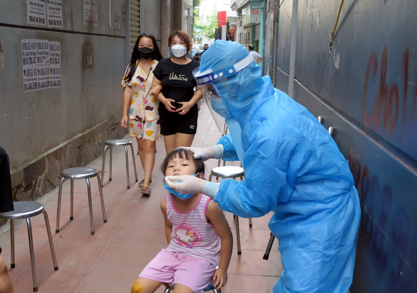 Lấy mẫu xét nghiệm những người hiện đang ở gần nhà của ca mắc COVID-19. (Ảnh: An Đăng/TTXVN)