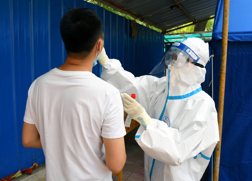 Nhân viên y tế lấy mẫu xét nghiệm COVID-19 cho người dân tại Bắc Kinh, Trung Quốc ngày 20/6. (Ảnh: THX/TTXVN)