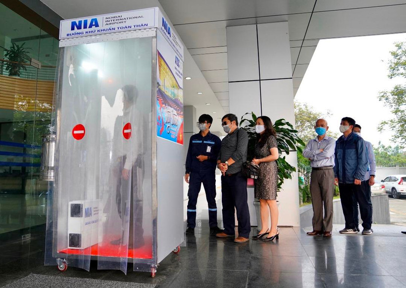 Nhân viên Cảng hàng không quốc tế Nội Bài đi qua buồng khử khuẩn toàn thân. (Ảnh: CTV/Vietnam+)