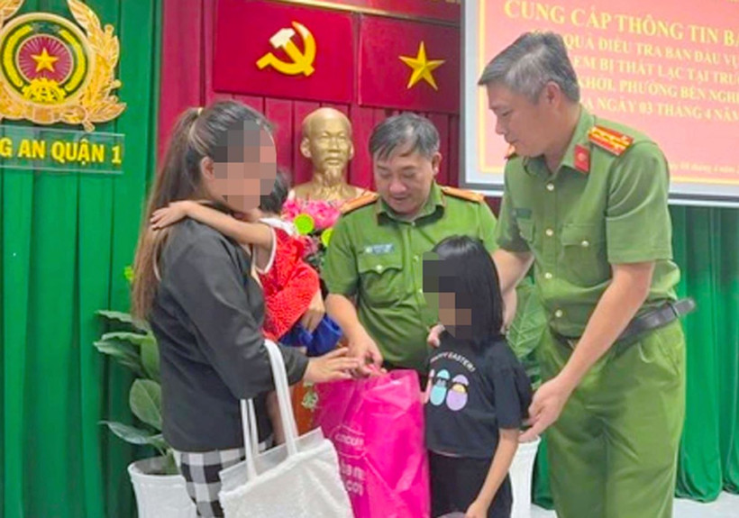Lực lượng Công an Thành phố Hồ Chí Minh trao trả hai cháu bé về với gia đình chị Nguyễn Thị Chi. (Ảnh: TTXVN phát)