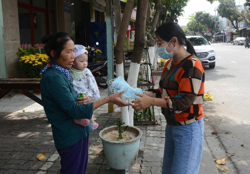 Chủ cửa hàng Bống Tea and Coffe (136C Ông Ích Đường, thành phố Đà Nẵng) phát khẩu trang miễn phí cho khách hàng. (Ảnh: Văn Dũng/ TTXVN)