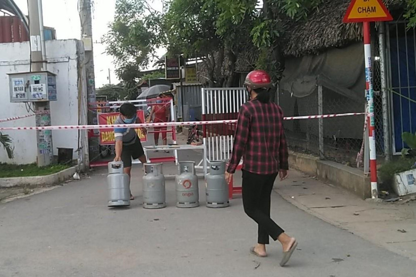 Đường vào đường Tân Phước Khánh 4, phường Tân Phước Khánh, thị xã Tân Uyên, tỉnh Bình Dương bi phong tỏa, người dân muốn đổi gas tại điểm phong tỏa về nấu bữa ăn tối ngày 20/6/2021. (Ảnh: Chí Tưởng-Thanh Cường/TTXVN)