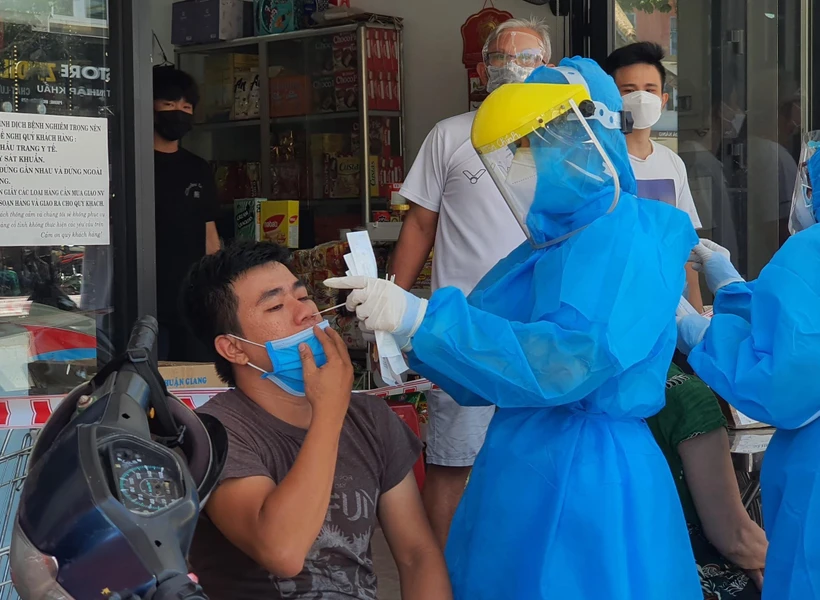 Nhân viên y tế lấy mẫu xét nghiệm của người dân quanh khu vực có ca mắc COVID-19 tại đường Lê Duẩn, Đà Nẵng. (Ảnh: Văn Dũng/TTXVN)