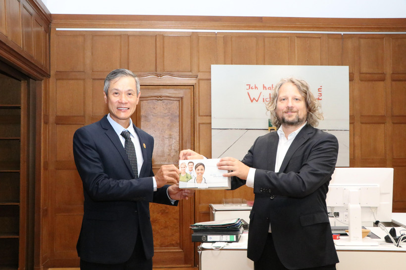 Ông Christian Rickerts - Quốc vụ khanh Bộ Kinh tế bang Berlin, đại diện cho chính quyền thủ đô Berlin trao tặng kit xét nghiệm cho Đại sứ Nguyễn Minh Vũ. (Ảnh: Vũ Tùng/TTXVN)