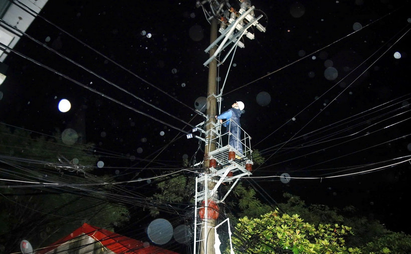 Công nhân điện lực khẩn trương khắc phục sự cố ngay trong đêm nhằm đảm bảo sinh hoạt cho nhân dân. (Ảnh: Thái Thuần/TTXVN)