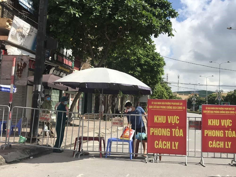 Người dân trong khu vực phong tỏa trên phố Ngô Quyền (Hải Dương) nhận thực phẩm tiếp tế tại hàng rào cách ly. (Ảnh: Mạnh Minh/TTXVN)