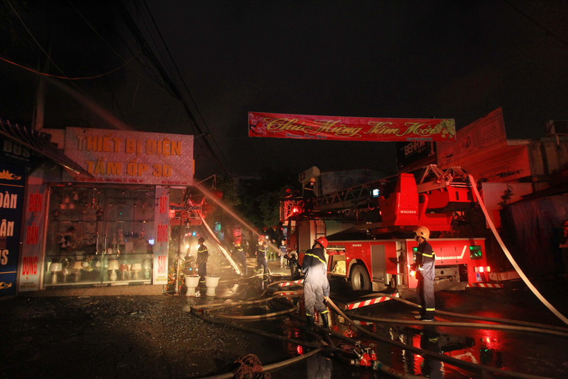 Lực lượng phòng cháy chữa cháy đang tích cực phun nước dập lửa, khống chế đám cháy. (Ảnh: An Đăng/TTXVN)