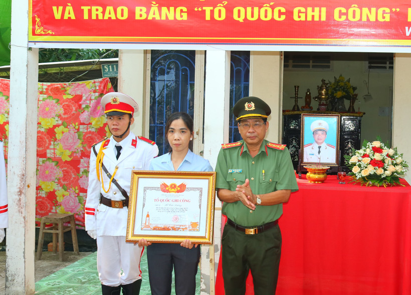 Đại tá Nguyễn Văn Hiểu trao Bằng Tổ quốc ghi công cho vợ Liệt sỹ Hồ Tấn Dương. (Ảnh: TTXVN phát)