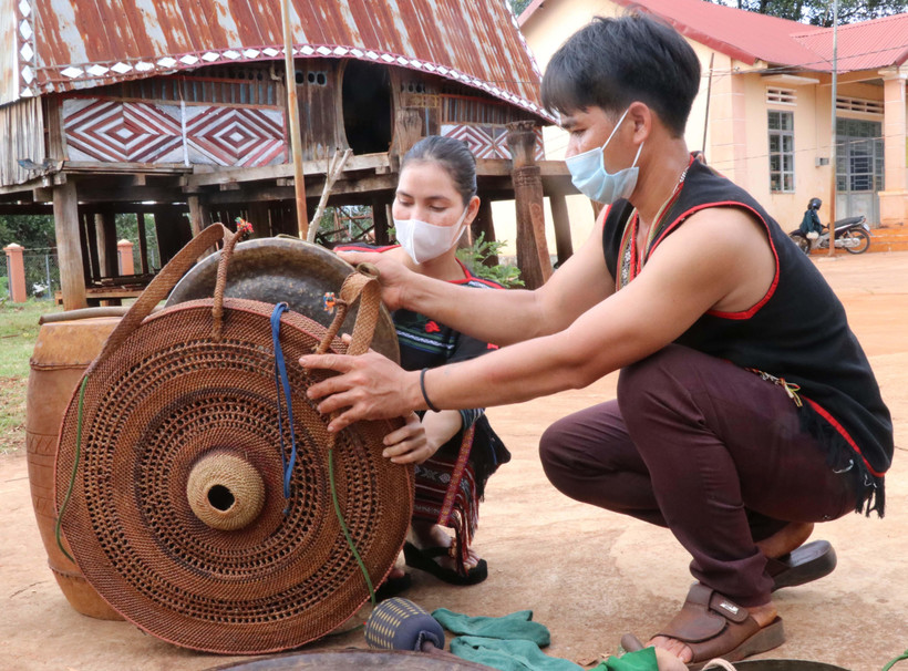 Thanh niên làng Mít Jep, xã Ia O (Ia Grai, Gia Lai) đan áo cho cồng, chiêng. (Ảnh: Hồng Điệp/TTXVN)