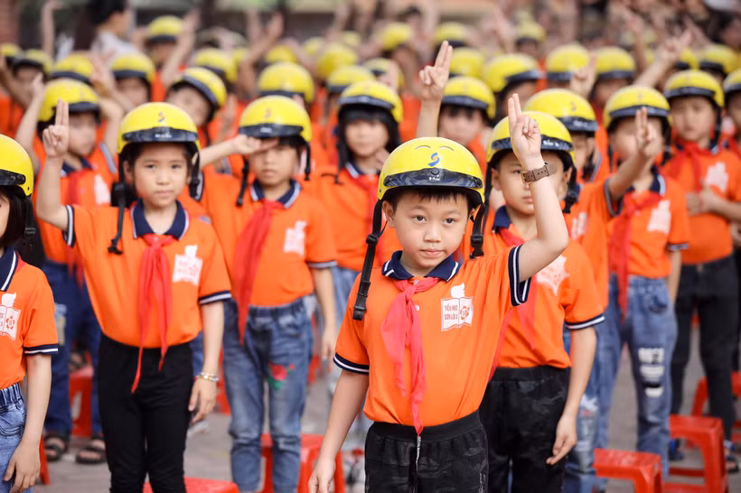 Học sinh trường tiểu học Sơn Lôi A tham gia hướng dẫn đội mũ bảo hiểm đúng cách. (Ảnh: CTV/Vietnam+)