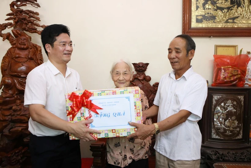 Phó Chủ tịch Thường trực UBND tỉnh Nam Định Trần Anh Dũng tặng quà cho Bà mẹ Việt Nam Anh hùng Trần Thị Chúc, sinh năm 1925, tại xã Mỹ Thắng. (Ảnh: Công Luật/TTXVN)