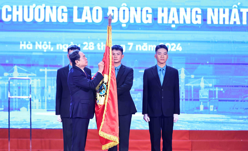 Chủ tịch Quốc hội Trần Thanh Mẫn gắn Huân chương Lao động hạng Nhất lên cờ truyền thống của Tổng Liên đoàn Lao động Việt Nam. (Ảnh: Minh Đức/TTXVN)