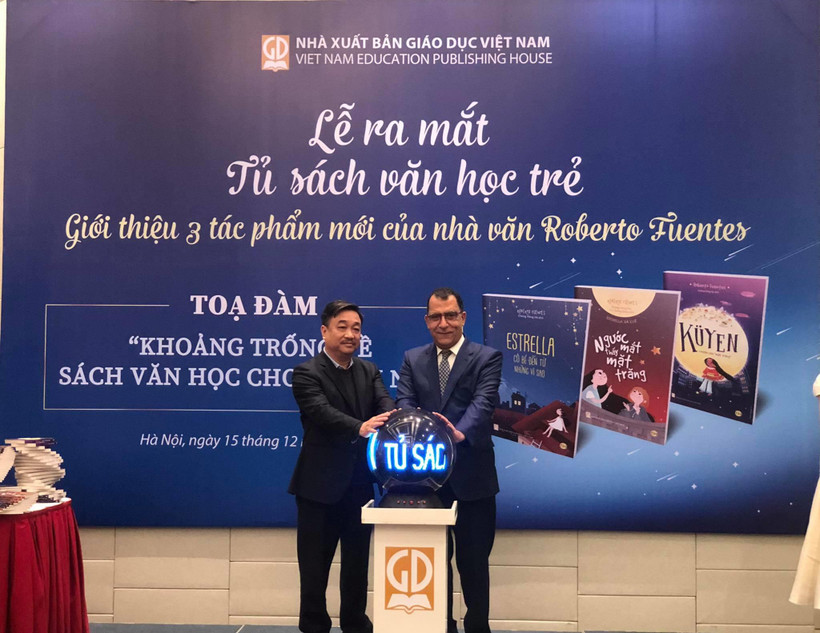 Tổng Giám đốc Nhà xuất bản Giáo dục Việt Nam Hoàng Lê Bách và Đại sứ Cộng hòa Chile Jaime Chomali Garib thực hiện nghi thức ra mắt Tủ sách văn học trẻ và ba tác phẩm văn học của nhà văn Chile Roberto Fuentes. (Ảnh: Phương Lan/Vietnam+)