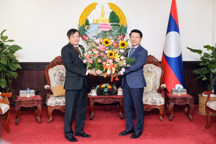 Đại sứ Nguyễn Bá Hùng tặng hoa chúc mừng 48 năm Quốc khánh nước Cộng hòa Dân chủ Nhân dân Lào. (Ảnh: Đỗ Bá Thành/TTXVN) 