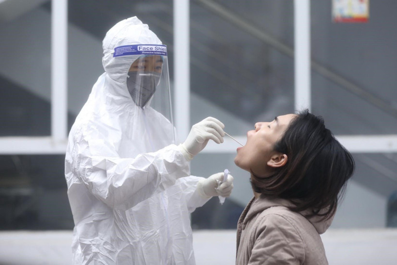 Nhân viên y tế lấy mẫu xét nghiệm cho người dân trở về từ vùng dịch, sáng 31/1. (Ảnh: Minh Quyết/TTXVN)