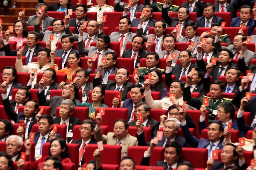 Các đại biểu biểu quyết, thông qua Nghị quyết Đại hội XIII Đảng Cộng sản Việt Nam. (Ảnh: TTXVN)