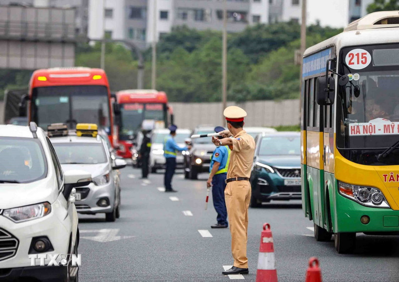 Lực lượng cảnh sát giao thông và thanh tra giao thông phân luồng phương tiện trên cao tốc Pháp Vân hướng đi vào Thủ đô Hà Nội. (Ảnh: TTXVN)