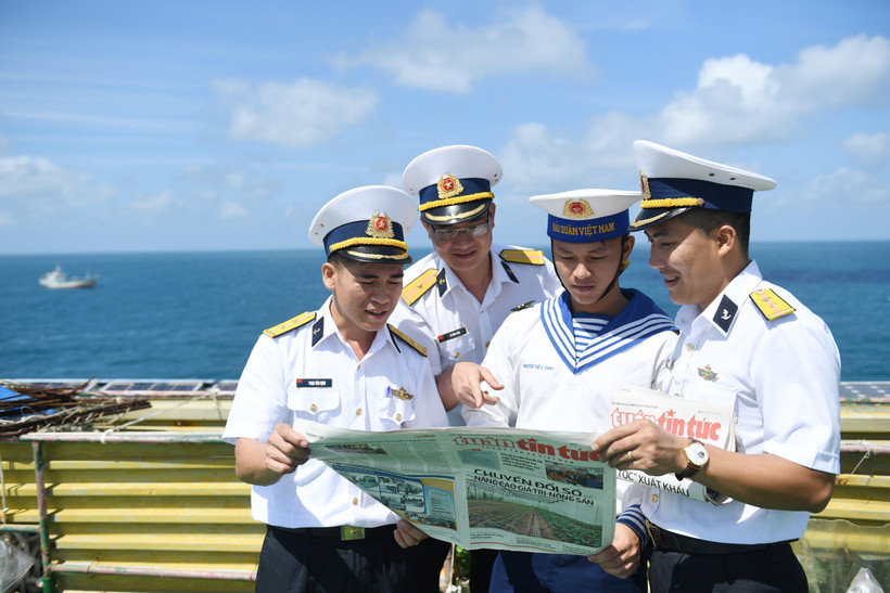 Các chiến sỹ nhà giàn DK1.10 với món ăn tinh thần là những tờ báo từ đất liền gửi ra. (Ảnh: Minh Đức/TTXVN)