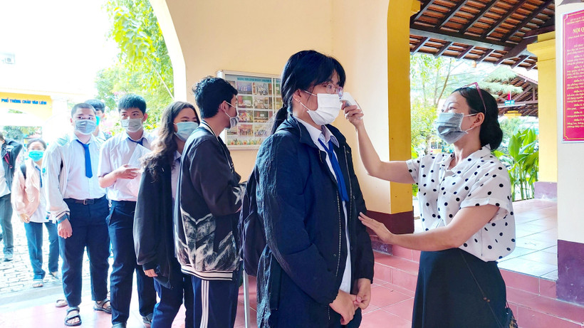 Thí sinh được đo thân nhiệt trước khi vào điểm thi. (Ảnh: Thu Hiền/TTXVN)