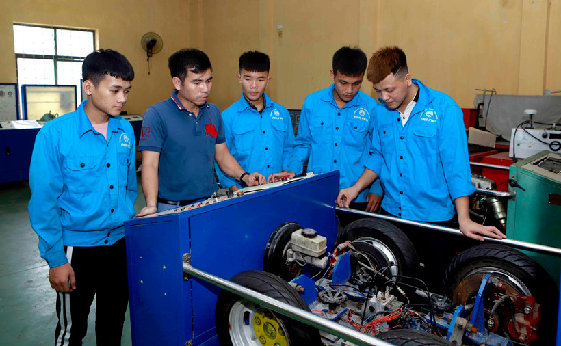 Giáo viên khoa Động lực Trường Cao đẳng nghề Vĩnh Phúc hướng dẫn cho sinh viên cơ chế hoạt động của hệ thống phanh ABS trên ôtô. (Ảnh: Hoàng Hùng/TTXVN)