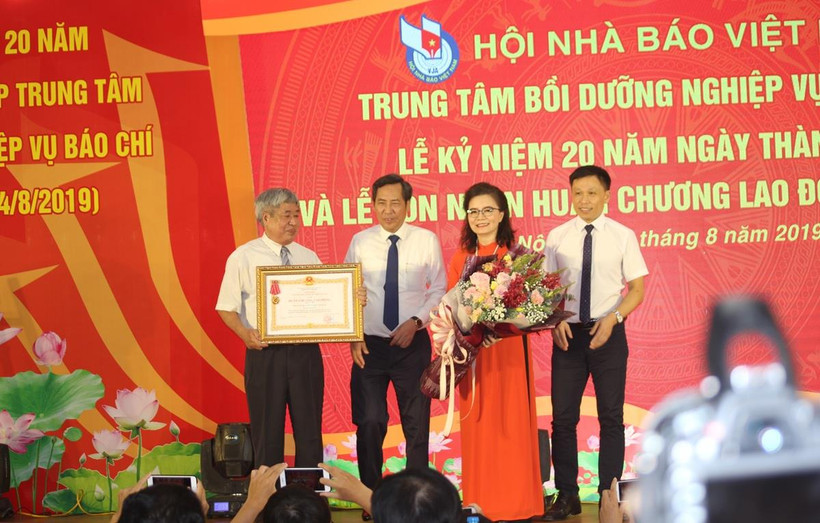 Nhà báo Thuận Hữu, Chủ tịch Hội Nhà báo Việt Nam (thứ 2 bên trái) trao tặng Huân chương Lao động hạng Nhì cho Trung tâm Bồi dưỡng nghiệp vụ báo chí. (Ảnh: H.V/Vietnam+)