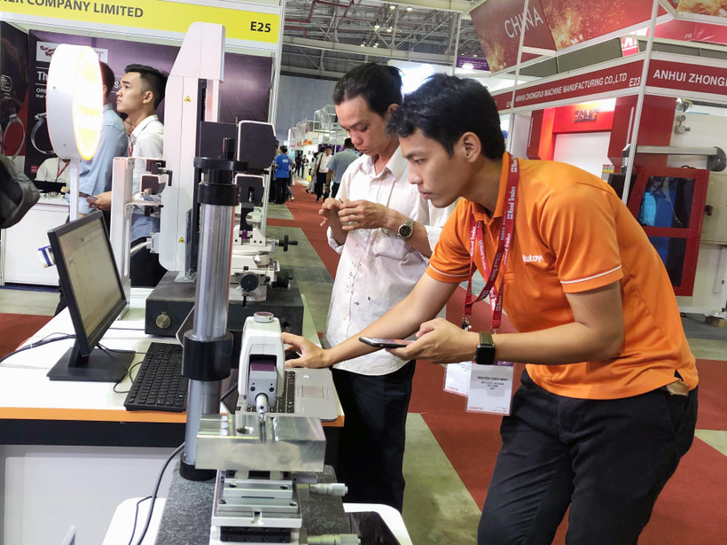 Khách tham quan trải nghiệp ứng dụng điều kiển thiết bị bằng điện thoại thông minh. (Ảnh: Mỹ Phương/TTXVN)