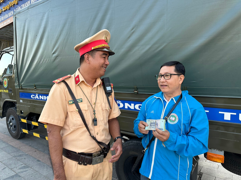 Người dân nhận lại tiền bị rơi. (Ảnh: TTXVN phát)