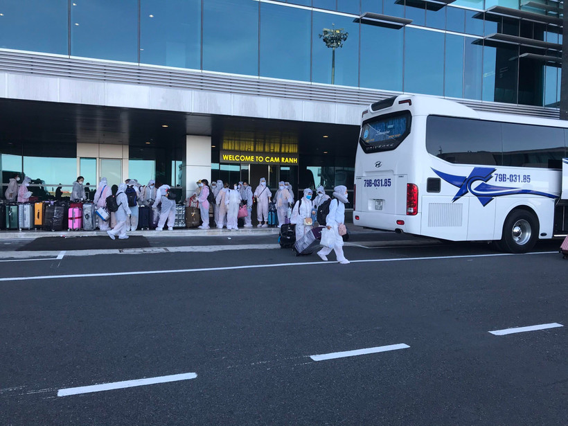 Công dân Việt Nam từ Đài Loan trở về nước lên xe đến các khu cách ly tập trung. (Ảnh: Phan Sáu/TTXVN)