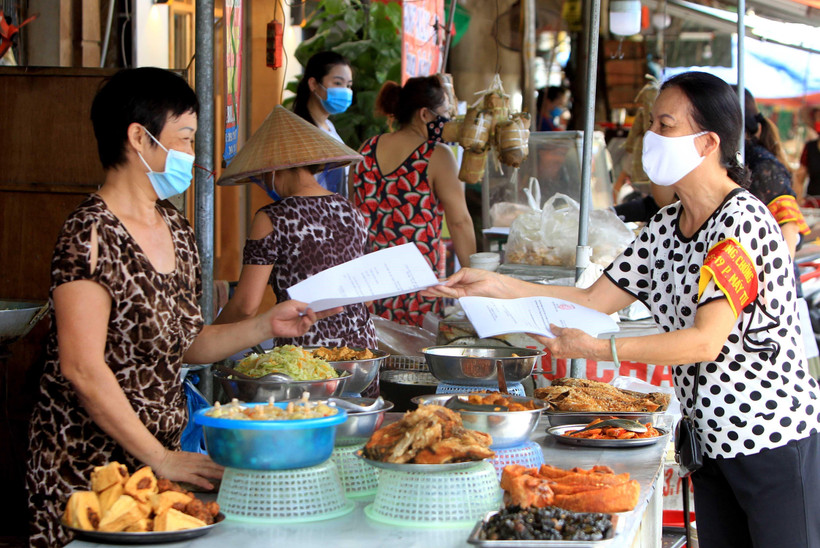 Các thành viên Ban Chỉ đạo phòng, chống dịch COVID-19 phường Máy Tơ, Hải Phòng, hướng dẫn bà con Tiểu thương thực hiện nghiêm các cam kết phòng chống dịch. (Ảnh: An Đăng - TTXVN)
