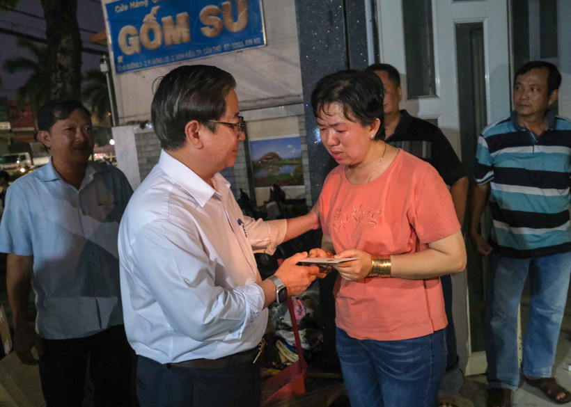 Chủ tịch UBND thành phố Cần Thơ Trần Việt Trường thăm hỏi, trao tiền hỗ trợ cho đại diện Cơ sở sửa chữa, mua bán phụ tùng ôtô Kim Thu. (Ảnh: Thanh Liêm/TTXVN)