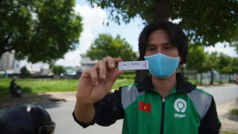 Đối tác tài xế của Gojek hào hứng khoe kết quả âm tính khi xét nghiệm nhanh COVID-19. (Ảnh: T.U/Vietnam+)