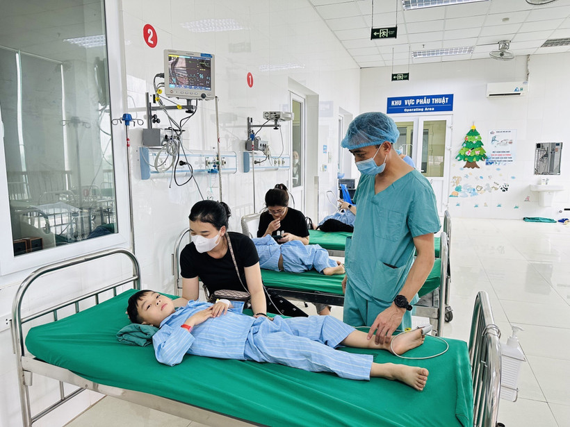 Bác sỹ Trần Minh Long kiểm tra sức khỏe bệnh nhi sau ca phẫu thuật. (Ảnh: Bích Huệ/ TTXVN)