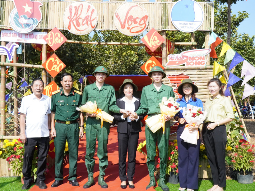 Hai anh em Nguyễn Tiến Thành và Nguyễn Tiến Đạt chụp ảnh lưu niệm cùng lãnh đạo huyện Phú Riềng và Ban Chỉ huy Quân sự huyện. (Ảnh: TTXVN phát)