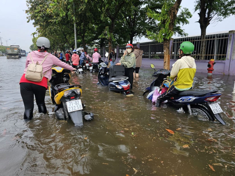 Trận mưa lớn khiến Khu công nghiệp Giao Long (huyện Châu Thành, Bến Tre) bị ngập nặng, công nhân phải lội bì bõm trong biển nước vào sáng 21/5. (Ảnh: Chương Đài/TTXVN)