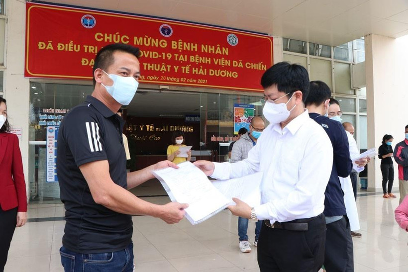 Ông Trần Trọng Khoa, Phó Cục trưởng Cục khám chữa bệnh, Bộ Y tế trao giấy ra viện cho bệnh nhân ra viện lần này. (Ảnh: Mạnh Minh/TTXVN)