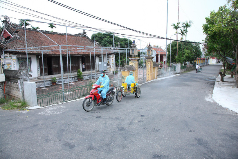 Phun thuốc khử trùng tiêu độc tại khu vực liên quan đến các ca dương tính với SARS-CoV-2 tại huyện Vĩnh Bảo ngày 24/6. (Ảnh: TTXVN)